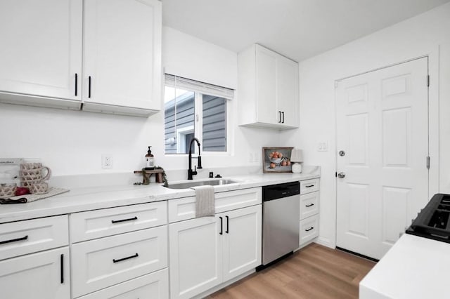 kitchen featuring dishwasher, white cabinets, light wood-type flooring, and sink