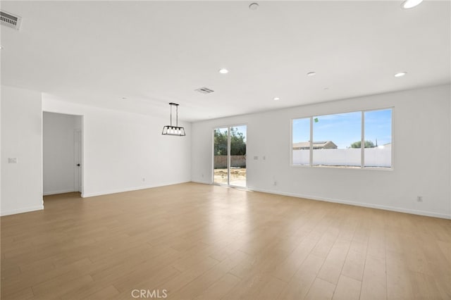 spare room featuring light wood-style flooring, recessed lighting, and visible vents