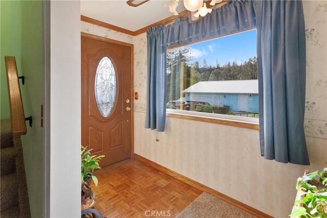 entrance foyer featuring ceiling fan, ornamental molding, and light parquet floors