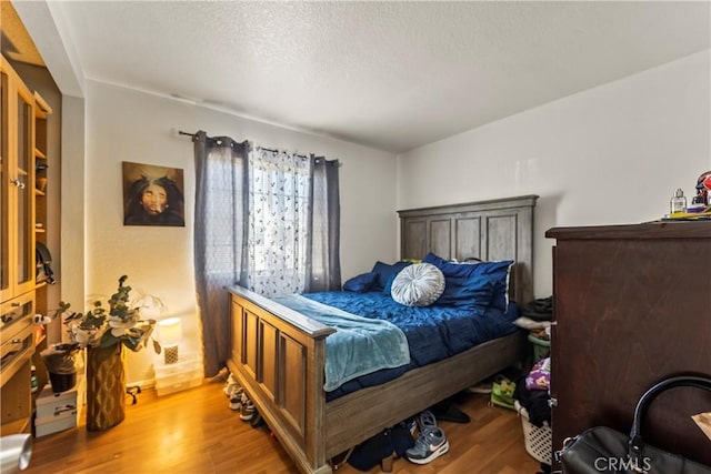 bedroom featuring hardwood / wood-style flooring and a textured ceiling