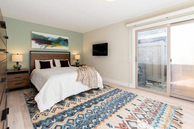 bedroom with access to exterior and light hardwood / wood-style flooring