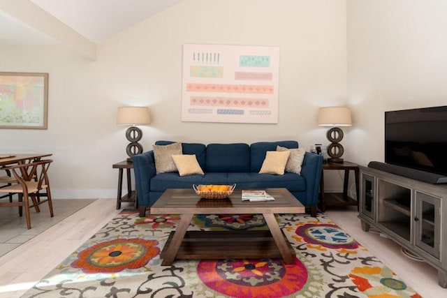 living room featuring lofted ceiling and light hardwood / wood-style flooring