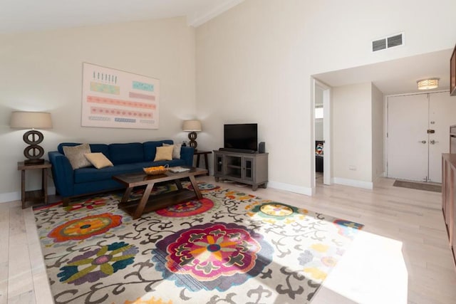 living room featuring high vaulted ceiling and light hardwood / wood-style floors