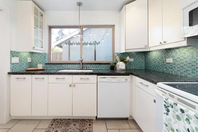 kitchen with white appliances, decorative backsplash, white cabinets, light tile patterned flooring, and sink