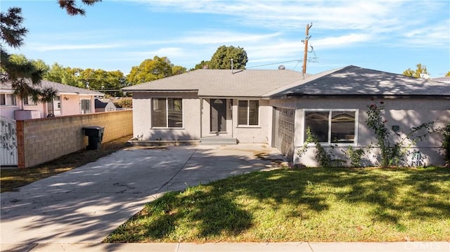 view of front facade featuring a front yard, fence, and stucco siding