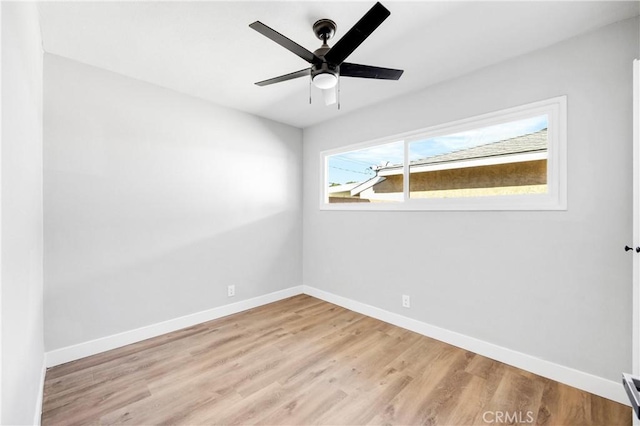 unfurnished room featuring a ceiling fan, baseboards, and wood finished floors