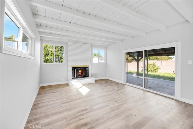 unfurnished living room with a brick fireplace, baseboards, and light wood-style floors