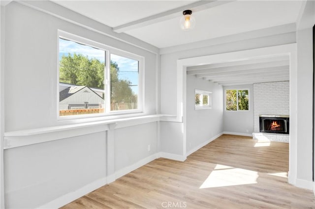 unfurnished sunroom with a fireplace and beamed ceiling