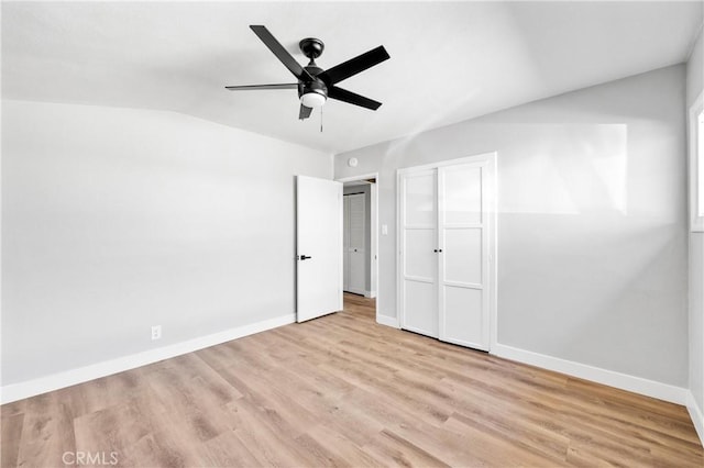 unfurnished bedroom with ceiling fan, lofted ceiling, light wood-style flooring, and baseboards