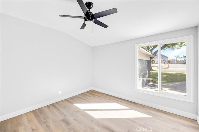 spare room with ceiling fan, baseboards, vaulted ceiling, and wood finished floors