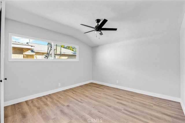 spare room featuring lofted ceiling, ceiling fan, baseboards, and wood finished floors