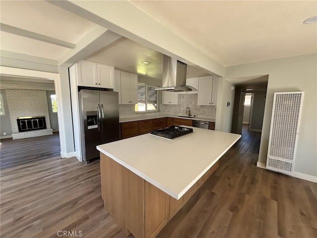 kitchen featuring island range hood, a sink, white cabinets, light countertops, and appliances with stainless steel finishes