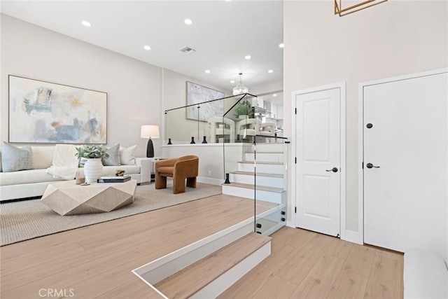 living room with light hardwood / wood-style flooring and an inviting chandelier