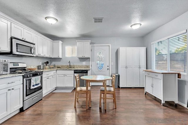 kitchen featuring stainless steel appliances, white cabinets, a textured ceiling, and sink