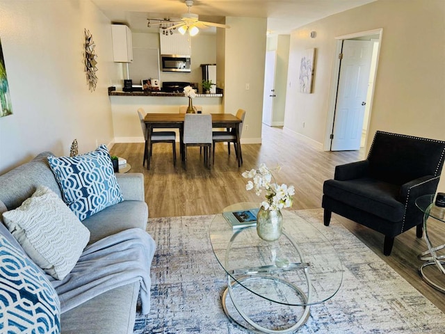 living room featuring ceiling fan and hardwood / wood-style floors