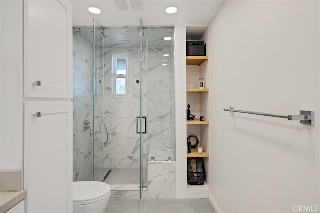 bathroom with toilet and a shower with door