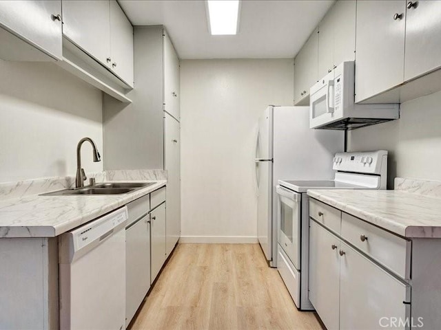 kitchen with white appliances, light hardwood / wood-style floors, and sink