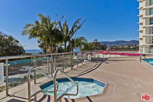 view of swimming pool featuring a mountain view and a community hot tub