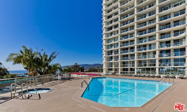 view of swimming pool featuring a mountain view and a patio area