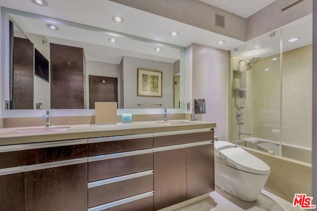 full bathroom featuring vanity, tiled shower / bath combo, and toilet