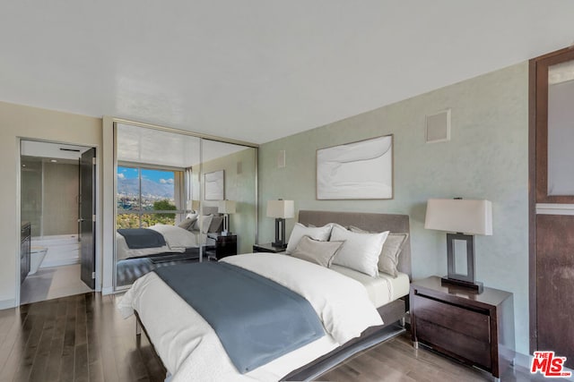 bedroom featuring ensuite bathroom, expansive windows, and wood-type flooring