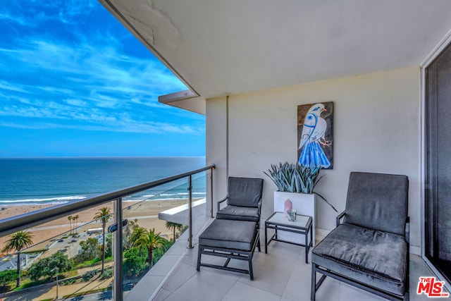 balcony featuring a beach view and a water view