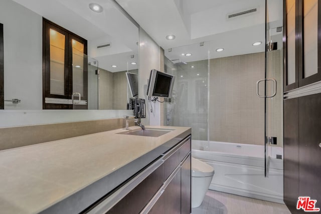 full bathroom with shower / bath combination with glass door, vanity, and toilet