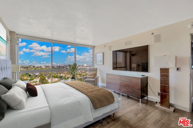 bedroom featuring hardwood / wood-style floors and expansive windows