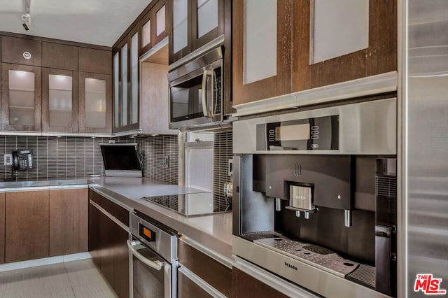 kitchen with dark brown cabinets, appliances with stainless steel finishes, and tasteful backsplash