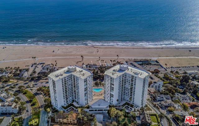 birds eye view of property featuring a water view and a beach view