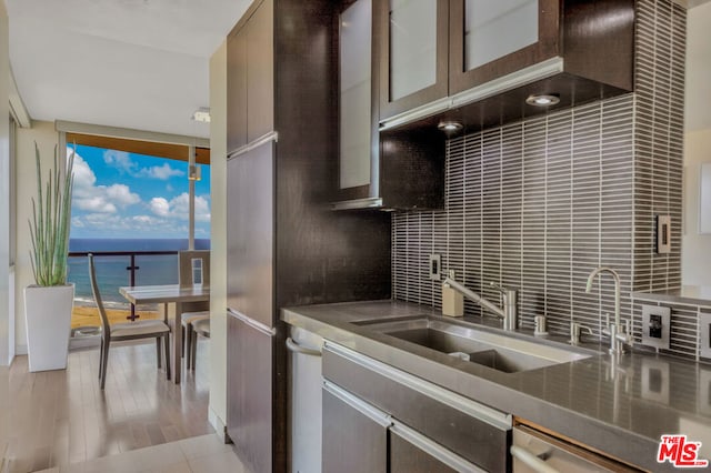 kitchen with dishwasher, backsplash, a water view, and sink