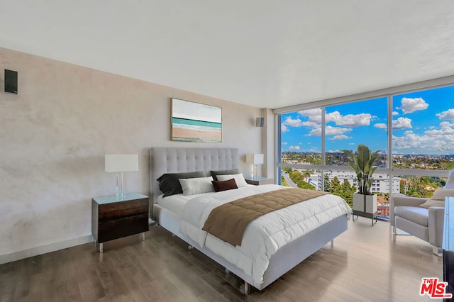 bedroom with expansive windows and dark wood-type flooring