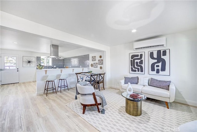 living room with light wood finished floors, recessed lighting, baseboards, and a wall mounted AC