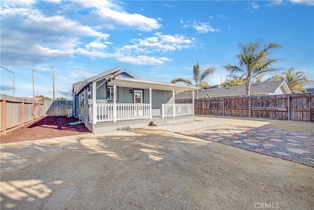 view of front of home with driveway, covered porch, and a fenced backyard