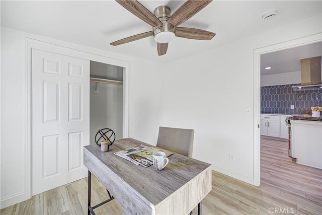 dining space featuring ceiling fan, light wood-style flooring, and baseboards