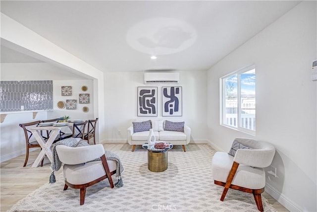 living area featuring a wall unit AC, wood finished floors, and baseboards