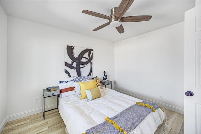 bedroom featuring a ceiling fan, baseboards, and wood finished floors