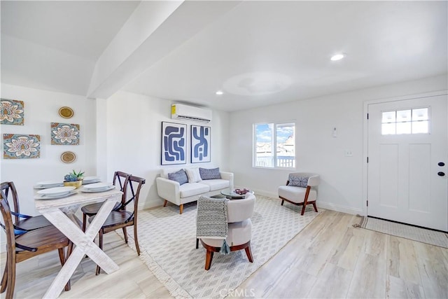 living area with baseboards, an AC wall unit, recessed lighting, and light wood-style floors