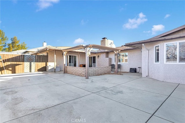 rear view of property with a patio area and a pergola