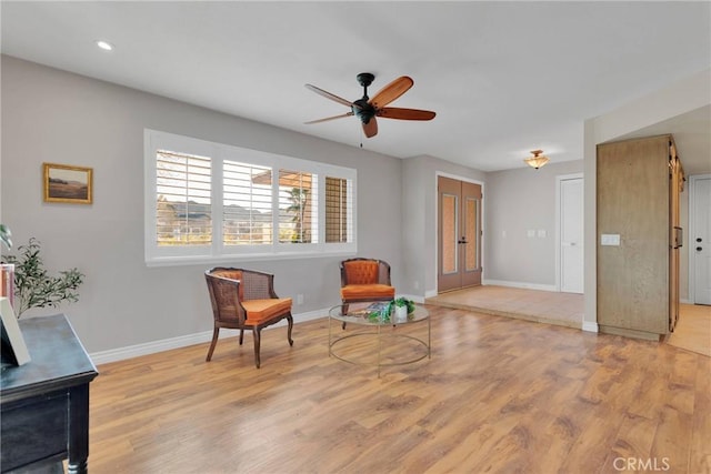 living area with ceiling fan and light wood-type flooring