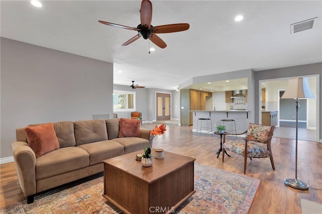 living room with ceiling fan and light wood-type flooring