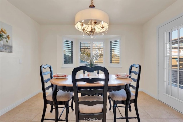 dining area featuring light tile patterned floors and an inviting chandelier