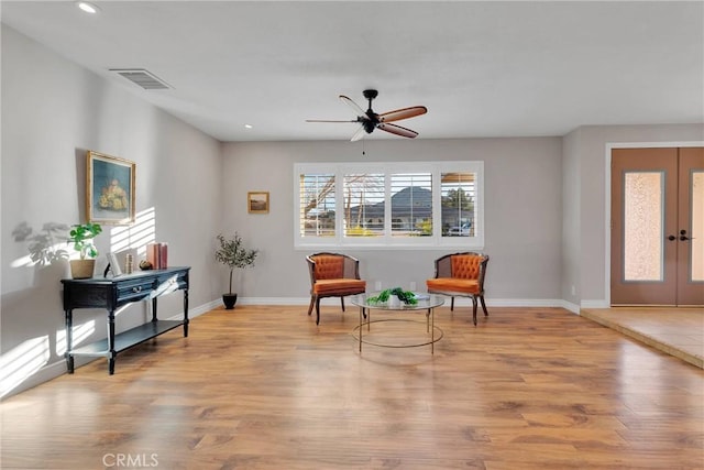 sitting room featuring ceiling fan, light hardwood / wood-style floors, and french doors