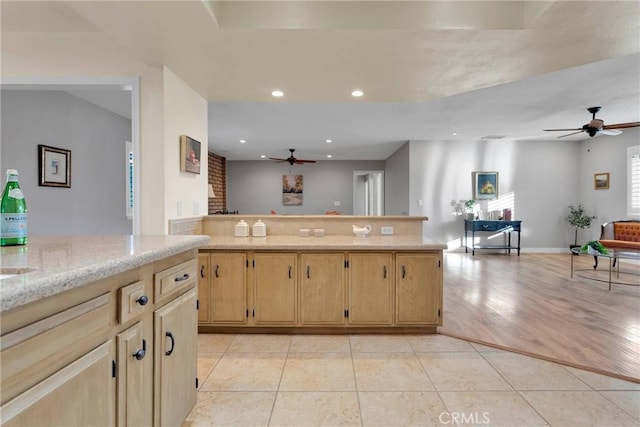 kitchen with ceiling fan, light stone countertops, light tile patterned floors, and light brown cabinetry