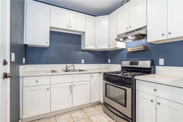 kitchen featuring gas stove, sink, white cabinets, and light tile patterned flooring