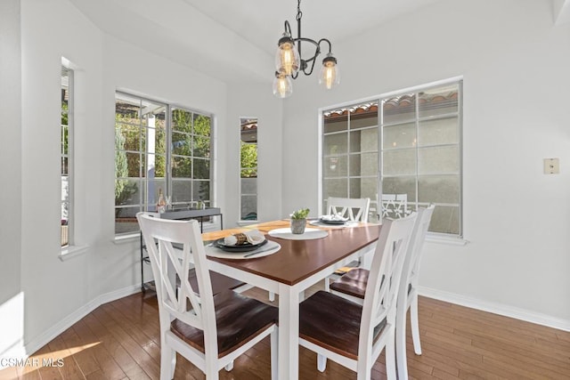 dining space featuring hardwood / wood-style floors and a notable chandelier