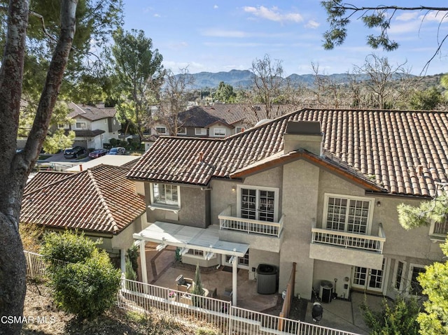 rear view of property with a mountain view, a pergola, a patio area, and central air condition unit