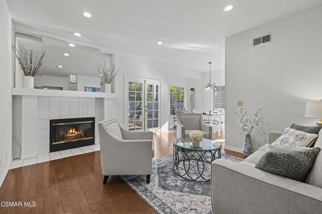 living room featuring a tiled fireplace and hardwood / wood-style floors