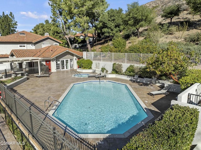 view of swimming pool featuring a patio area and a community hot tub