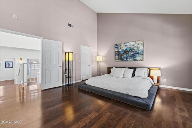 bedroom with dark hardwood / wood-style floors and high vaulted ceiling